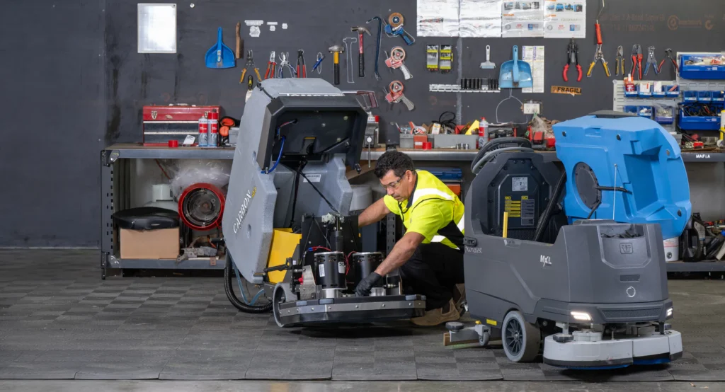 Conquest service technician working on a floor scrubbing machine.