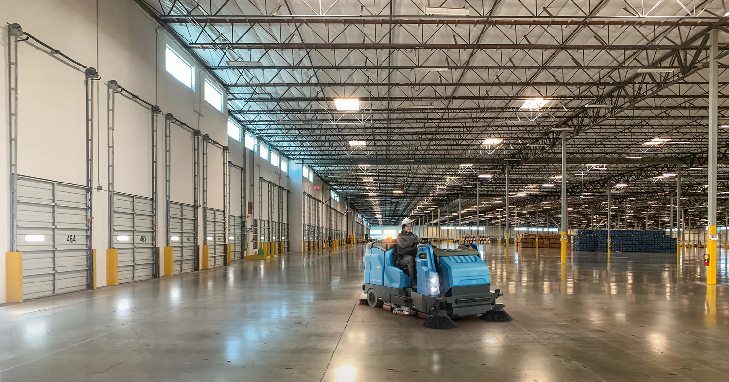 Conquest HDC170 combination sweeper scrubber cleaning large warehouse floors in industrial facilities