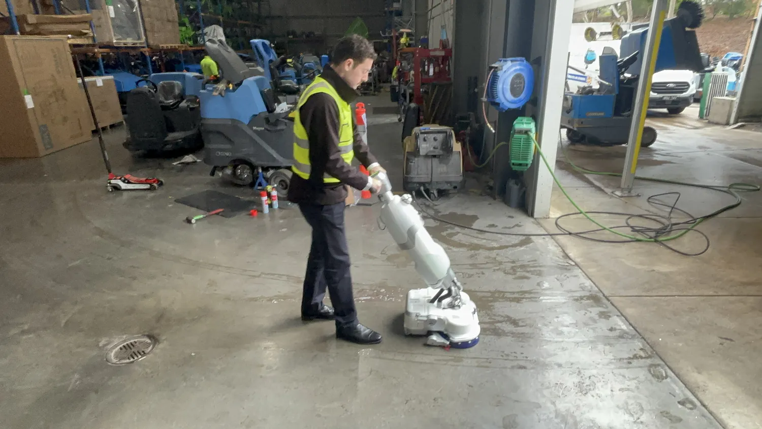Conquest HDS46 walk-behind floor scrubber cleaning sealed concrete flooring in a commercial workshop environment
