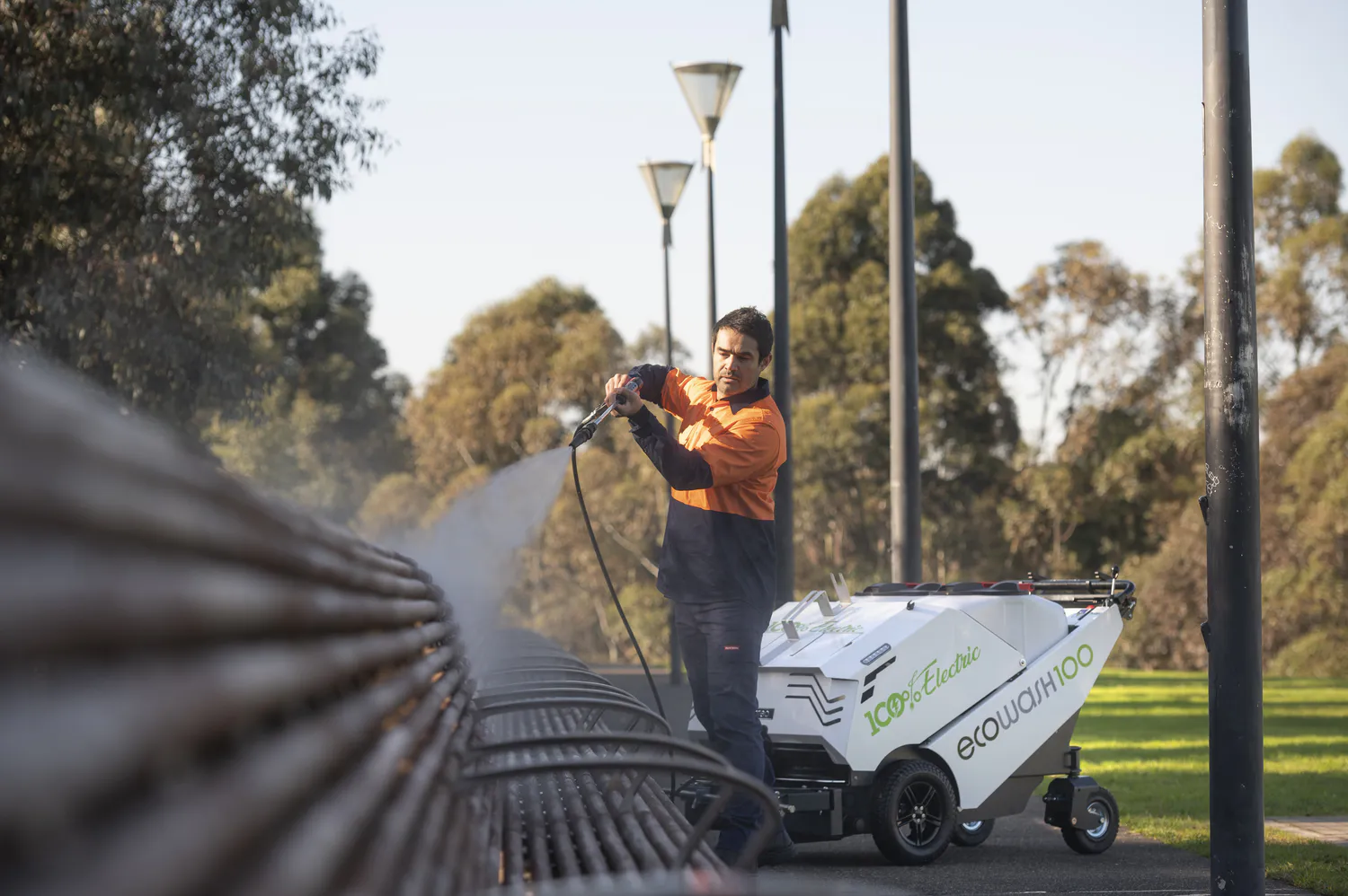 Conquest HDSW100 street washer with spray lance removing dirt from park seating and surrounding public areas